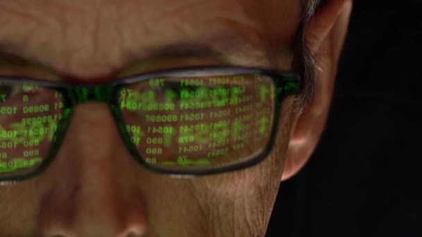 Der Programmierer mit der Brille vor dem Display. Spiegelung des Monitors mit einem numerischen Code. — Stockvideo