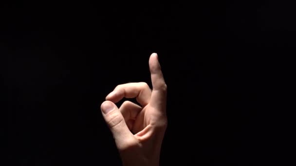 Slim Male Hand Reaching Out to Light on Black Background — Stock Video