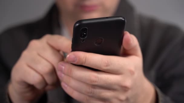 A férfiak kezében van egy okostelefon. A férfi okostelefont használ. — Stock videók