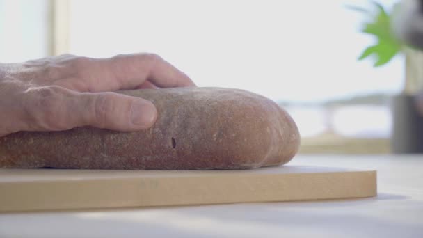 Krájení bochníku chleba v kuchyni — Stock video