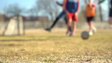 Bulanık video. Ağır çekim. Antrenman sırasında genç futbolcuların bacakları