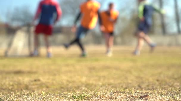 Wazige video. Langzame beweging. Benen van jonge voetballers tijdens de wedstrijd in training — Stockvideo