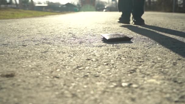 Mannen hämtar plånboken från trottoaren. Begreppet vårdslöshet och förlust av pengar — Stockvideo