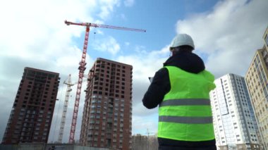 İnşaat alanındaki danışman mühendis elinde planı tutuyor. İnşaat müfettişi. İnşaat alanı teftiş çizimi ve yeni inşaat iş akışı
