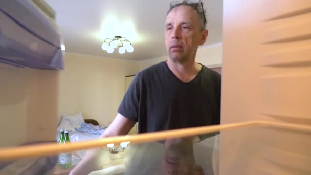 Hungrig äldre man med roligt ansikte öppnar tomt kylskåp — Stockvideo