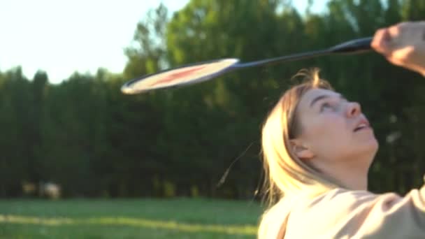 Молода жінка грає в бадмінтон, активні ігри влітку на природі — стокове відео