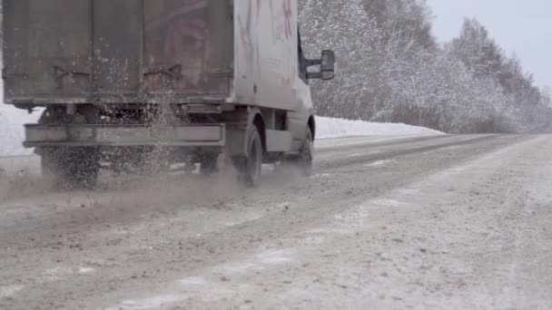 Loose neve vola da sotto camion ruote sulla strada principale — Video Stock