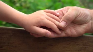 Bir büyükanne ve bir çocuğun elleri, el ele. Anne bakımı.