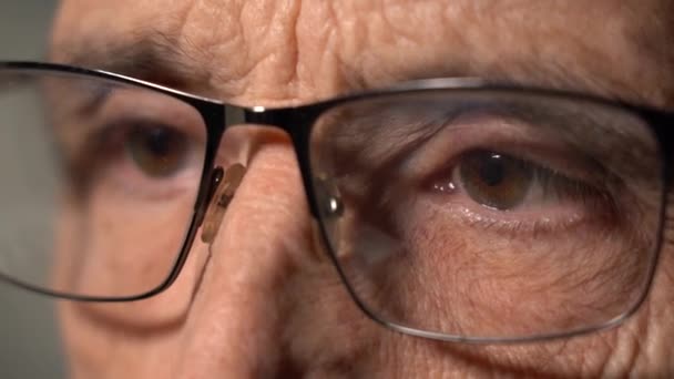 Close-up van een volwassen man met een bril om de oogspanning te verminderen — Stockvideo