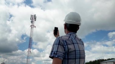Telekomünikasyon mühendisi, telekomünikasyon kulesinin yedek parçasını değiştiren teknisyenle sinyali kontrol ederken...