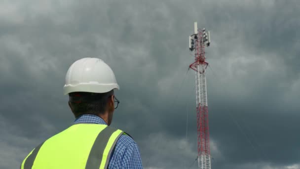 Ingeniero de telecomunicaciones comprobando la señal desde una torre de telecomunicaciones — Vídeo de stock