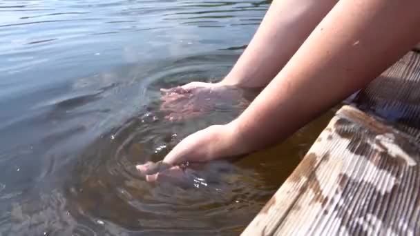 Чистая вода в реке. Человек рукой черпает чистую речную воду ладонью. Медленное движение — стоковое видео