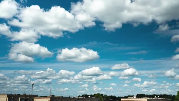 许多小云在屋顶上的移动。一段美丽而晴朗的蓝天，白云飘扬的录像。云彩由左向右移动 — 图库视频影像