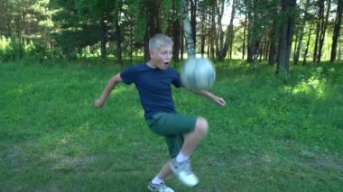 12 yaşında bir çocuk parktaki bir açıklıkta topla oynuyordu. Sokak futbolu. Yavaş çekim