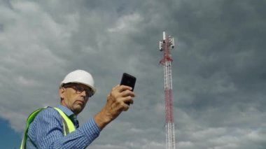 Telekomünikasyon mühendisi bir telekomünikasyon kulesinden gelen sinyali kontrol ediyor..