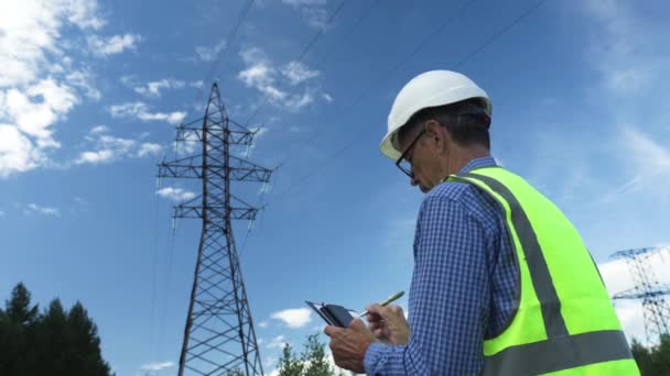Ingeniero eléctrico trabaja inspeccionando líneas eléctricas — Vídeos de Stock