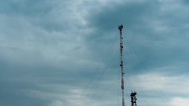 Cep telefonu kulesi ve gri bulutlu yağmurlu gökyüzü, zaman atlaması. Mobil Operatörler Kulesi üzerinde gökyüzü ve bulutların arkaplanı