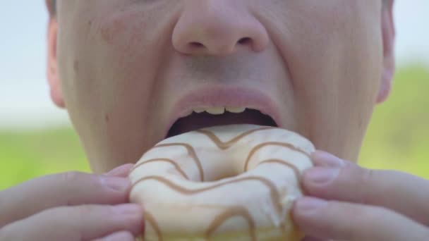 O gordo está a comer um donut. Close-up — Vídeo de Stock