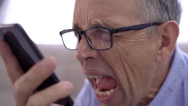 Zły starszy biznesmen krzyczy przez telefon, jest sfrustrowany i rozczarowany — Wideo stockowe