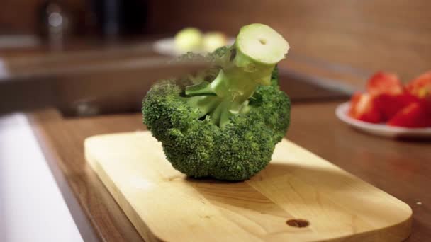 Mutfak bıçağıyla erkek eli, tahta kesme tahtasıyla taze brokoli kesti. Sağlıklı beslenme — Stok video