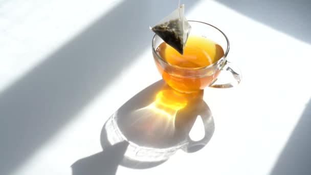 Chá da manhã verde. Saco de triângulo de chá em uma xícara de chá. Brew Green Tea em uma caneca. Close-Up. Vista de cima — Vídeo de Stock