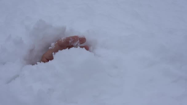 Uma mão humana sai da neve depois de uma avalanche. A pessoa presa na neve ainda está viva e precisa de ajuda — Vídeo de Stock