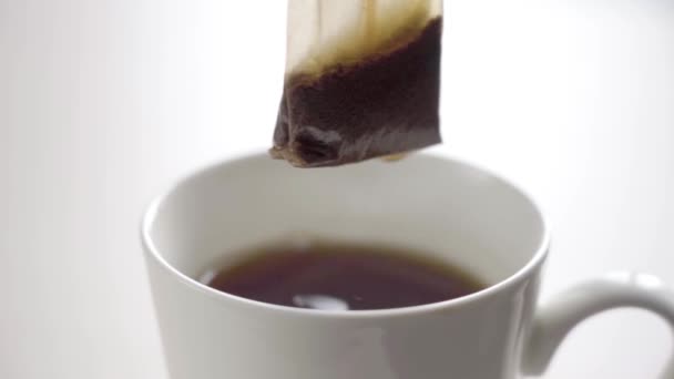 Taza de té negro aislado en blanco — Vídeo de stock
