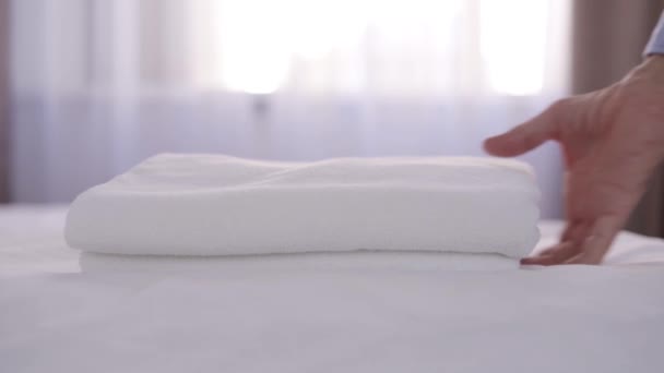Seniorin holt sauberes Handtuch aus dem Bett im Zimmer — Stockvideo