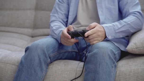 Irriconoscibile giovane ragazzo che gioca ai videogiochi con joystick a casa — Video Stock