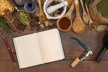 Açık kitapçıkta metin için alanı olan baharatlar ve otlar pişiriliyor.