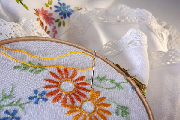 Embroidery or Needlepoint - the craft of decorating fabric or other materials using a needle to apply thread or yarn. Embroidery may also incorporate other materials such as pearls, beads, quills, and sequins.