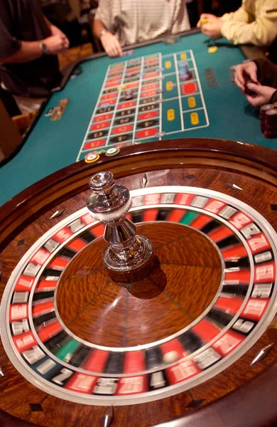 Roulette table in a Las Vegas casino.  Roulette is a gambling game in which a ball is dropped on to a revolving wheel with numbered compartments, the players betting on the number at which the ball comes to rest.