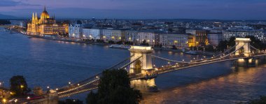 Budapeşte, Macaristan 'ın akşam silueti. Macar Parlamento Binası ve Tuna Nehri üzerindeki Szechenyi Zinciri Köprüsü 'nün simgeleri de dahil olmak üzere kente bakın..