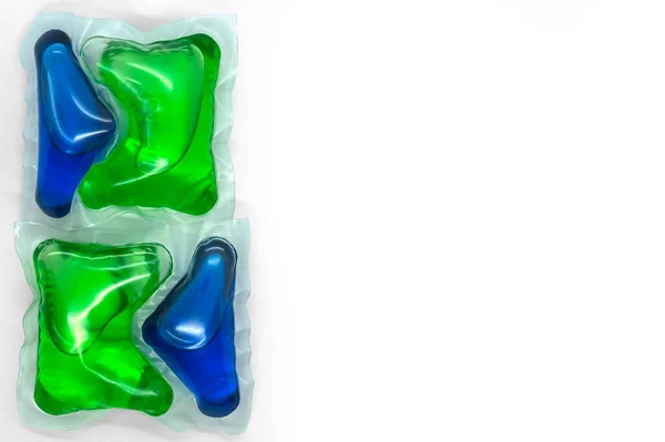 Kapszula kék-zöld géllel fehér háttér fénymásoló felületen történő mosáshoz — Stock Fotó