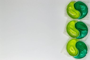 Beyaz arka planda yeşil ve sarı jel ile yıkama kapsülleri