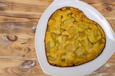 Ahşap bir yüzey üzerinde beyaz bir tabakta armut turtası yakın plan