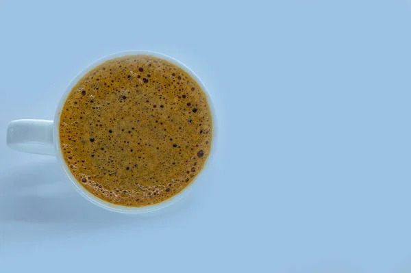 Белая чашка с кофе эспрессо на синем фоне — стоковое фото