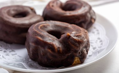 Beyaz bir tabakta yuvarlak çikolatalı pasta.