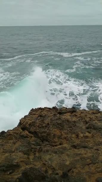 Волны разбиваются о скалы — стоковое видео