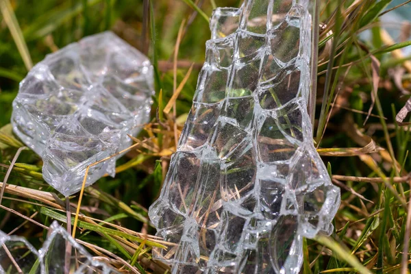 A close up of Shattered glass on the grass