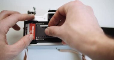 Fotoğrafçı 35 mm 'lik fotoğraf makinesiyle siyah & beyaz Ilford filmi yüklüyor