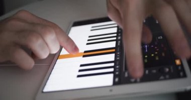 Kullanıcı tablet uygulama müzik prodüksiyon yazılımında dijital piyano sentetiği çalıyor
