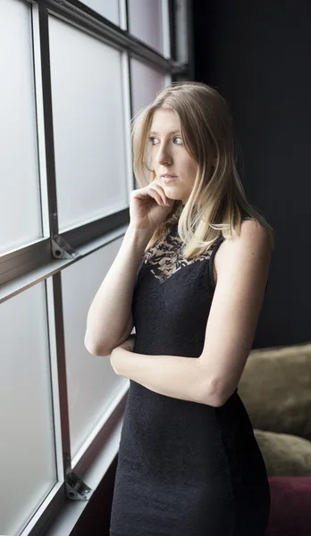 Blond kvinde i sexet sort kjole - Stock-foto