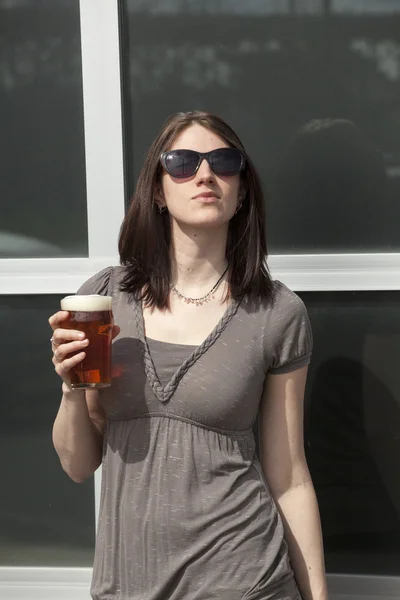 Schöne junge Frau mit braunen Haaren trinkt ein Pint — Stockfoto