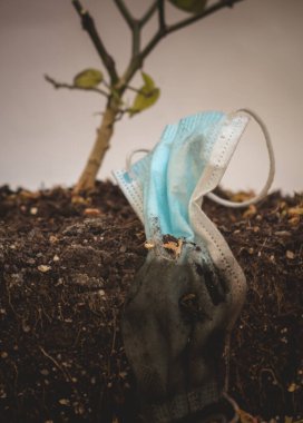 Yerde kullanılmış tıbbi maske. Salgın sonrası çöplük. Toprak kirliliği..