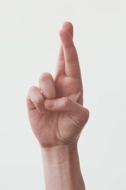 Parmaklarını çapraz yap. Beyaz arkaplanda bir kadın eli.