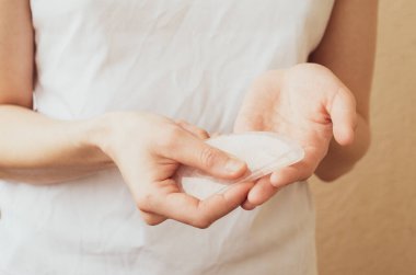 Beyaz bir arka planda pembe gua sha yüz masajı yapan bir kadın. Cilt bakımı için Rose Quartz.