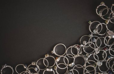 Koyu arkaplanda gümüş yüzükler. El yapımı mücevherler. Metin için boşluk.