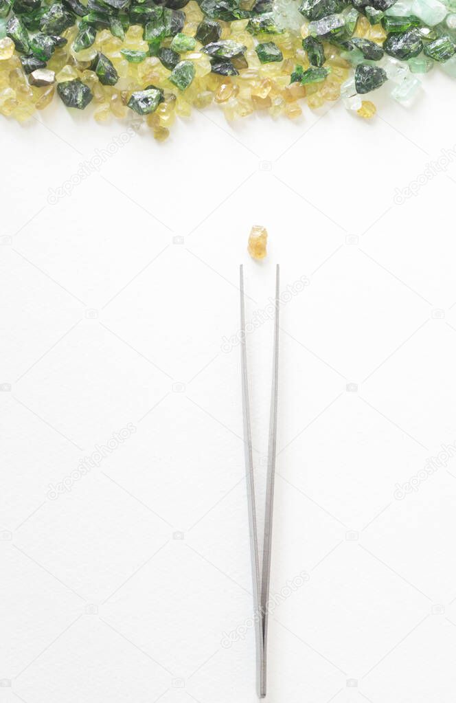 gems and tweezers on a white background