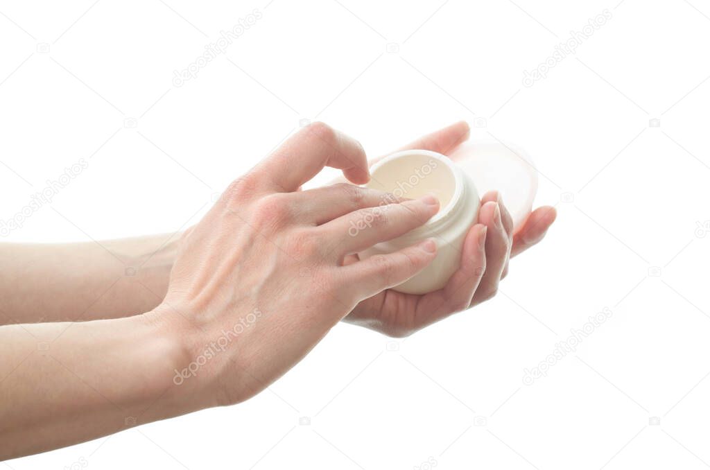 A woman holds a jar of hand cream